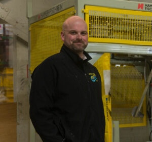 Andrew Burleigh, American Ag Systems Co-founder, smiling inside a facility