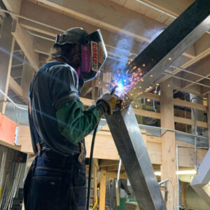 Employee welding agriculture equipment.